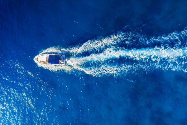 Bateau en pleine vitesse vu du ciel – Port Camargue Bateau rapide filmé en vue aérienne laissant un sillage blanc sur une mer bleu profond à Port Camargue.