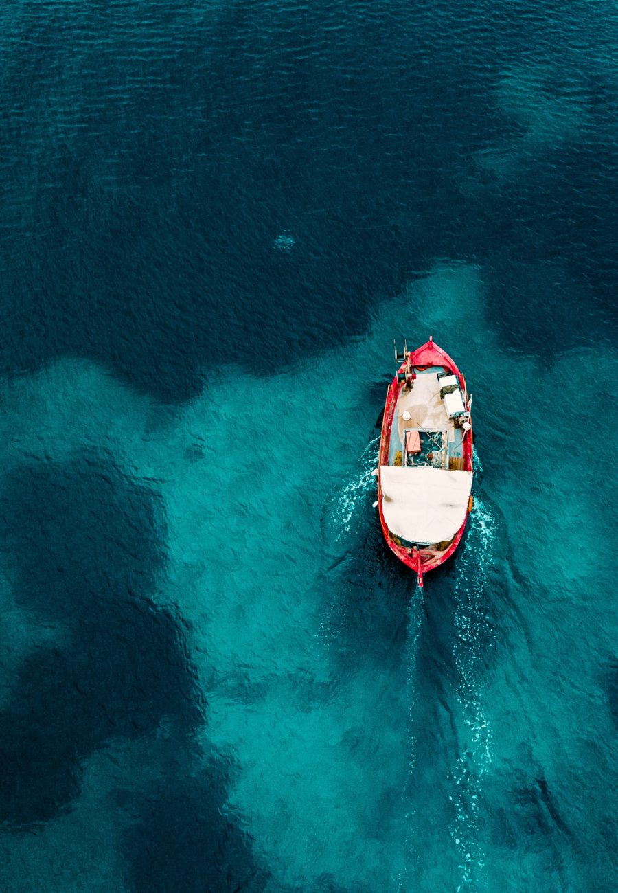 Aerial view of old fishing boat in blue sea in Greece. Aerial view of old fishing boat in blue sea in Greece.
