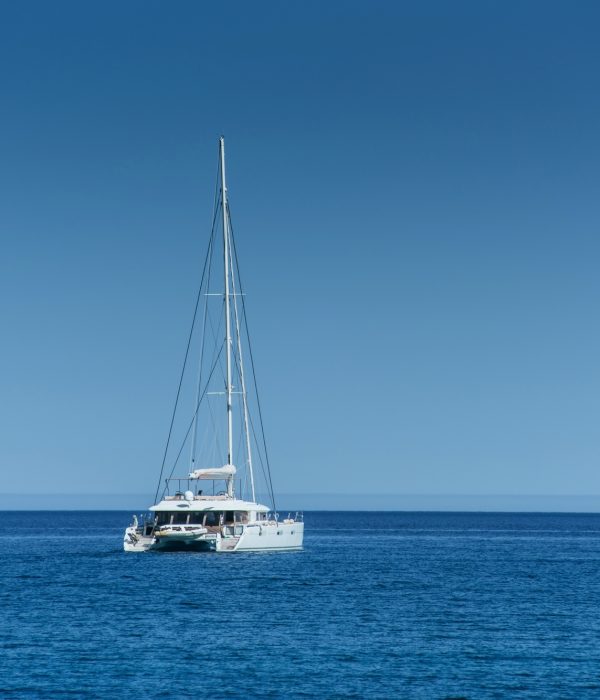 Catamaran en mer au large de Port Camargue – Permis bateau côtier Un catamaran blanc au large sur une mer calme et bleue, illustrant la navigation en mer ouverte pour le permis côtier.
